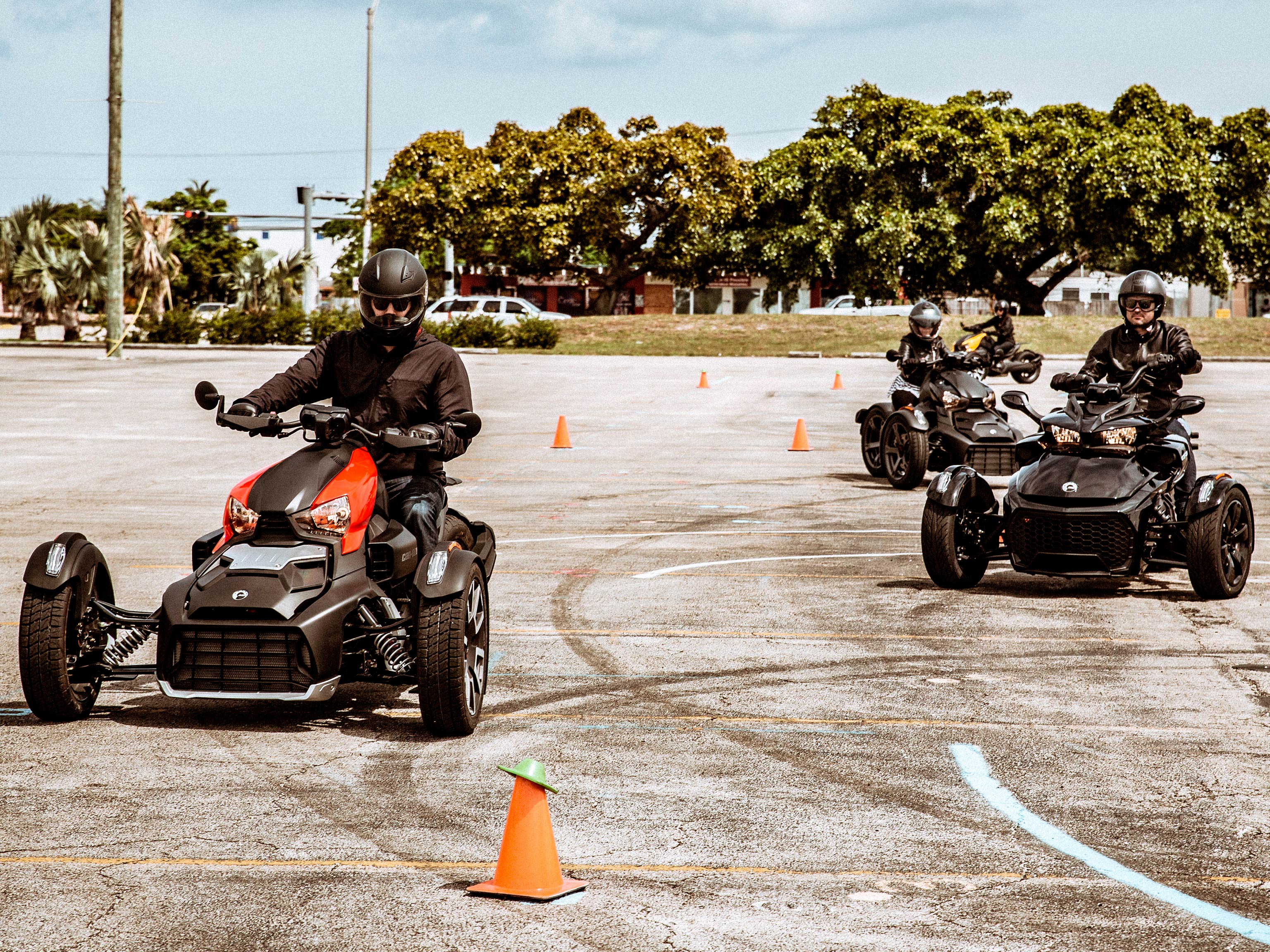 Students driver driving in between orange cones on Can-Am 3-wheel vehicles