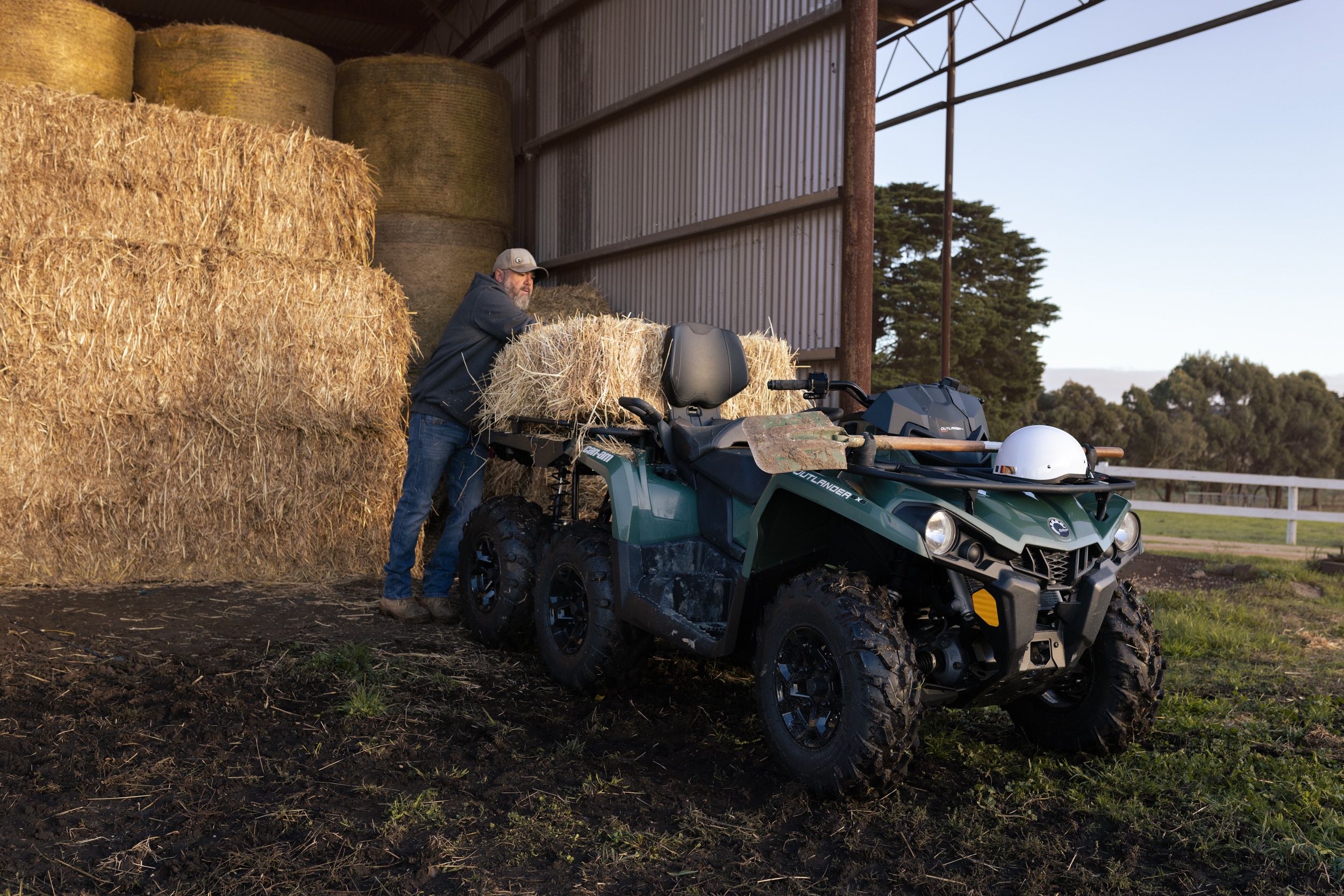 Man loading hay bales onto Can-Am Outlander 6x6