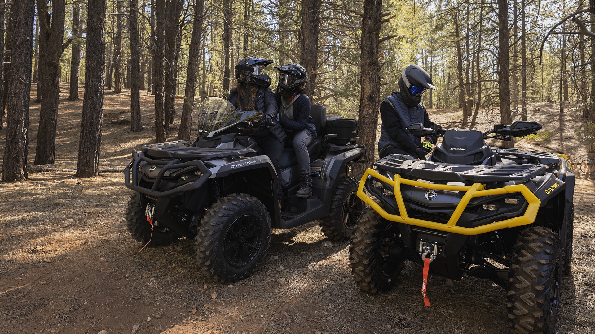 Can-Am Outlander ATV riders getting ready for a ride in the forest