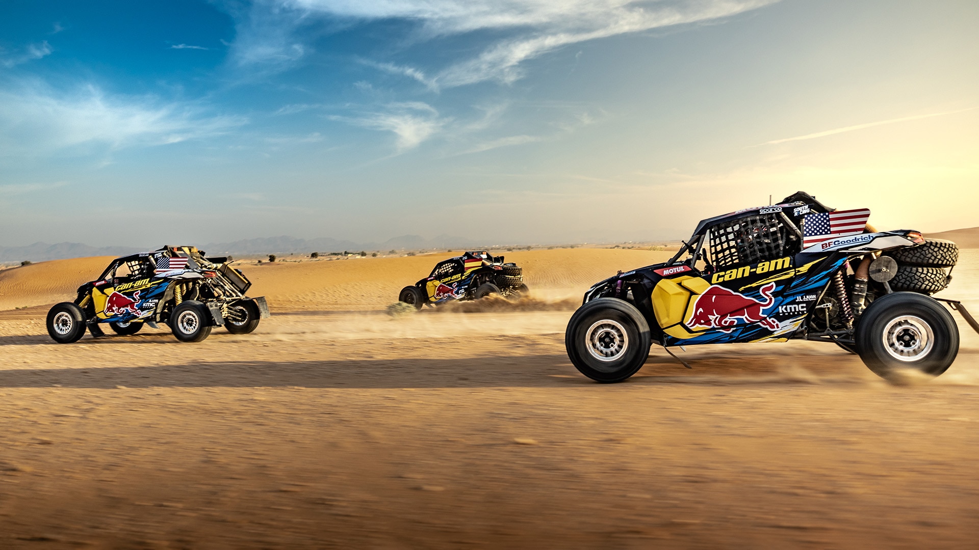 Three Can-Am Maverick X3 side-by-side vehicles racing in the desert