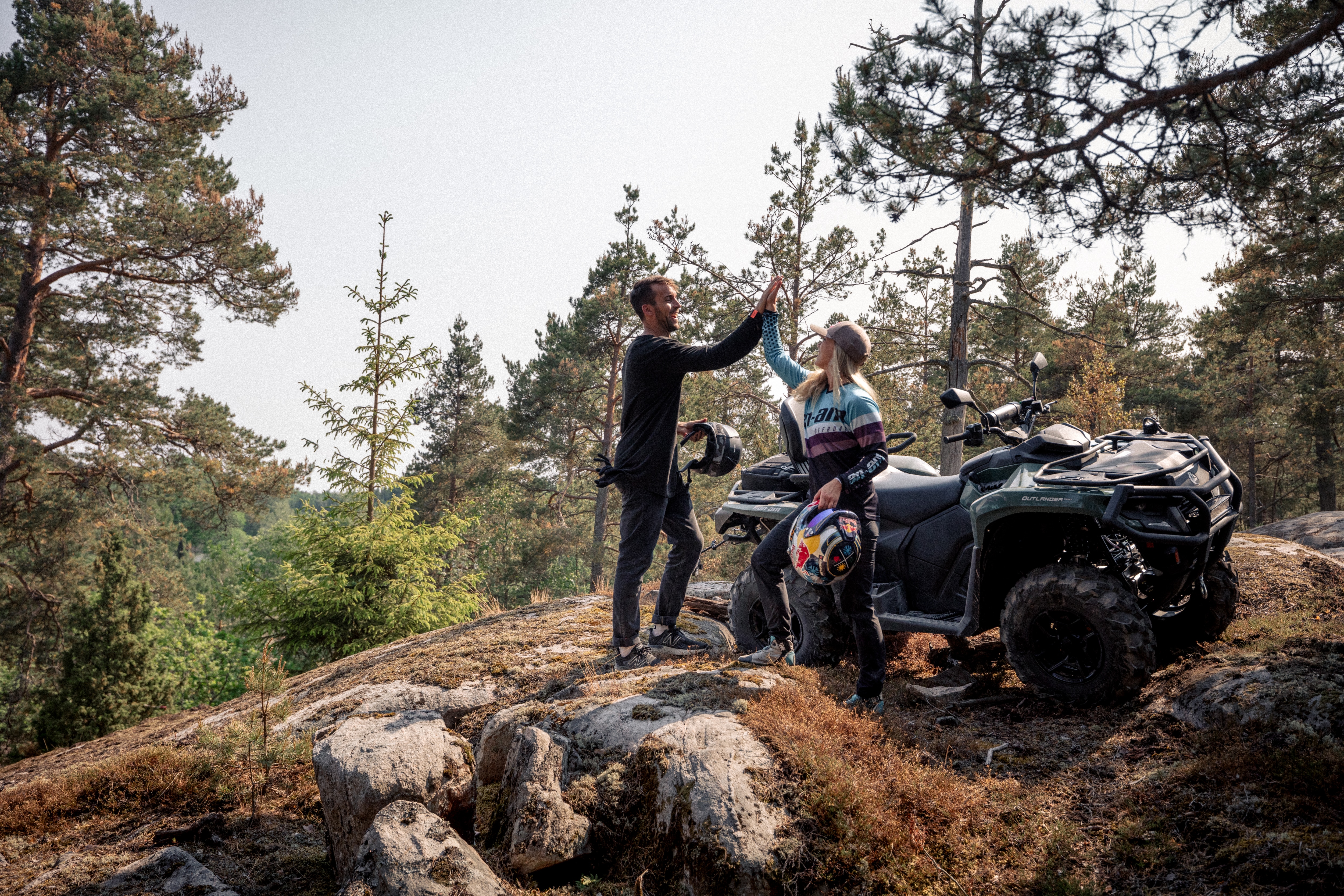 En mann og en kvinne på en ATV i skogen