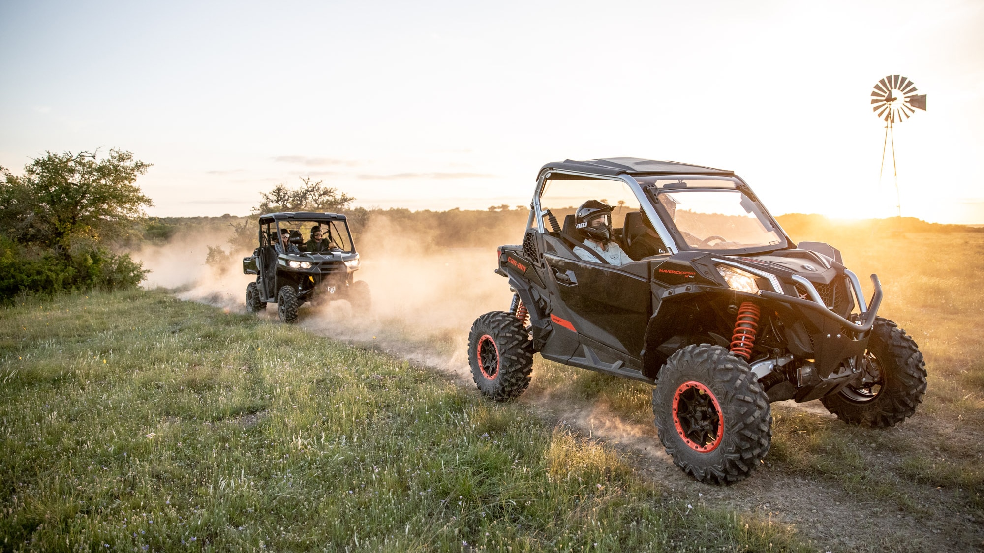 People riding Can-Am Maverick Sport X xc and Can-Am Defender XT side-by-sides in a trail
