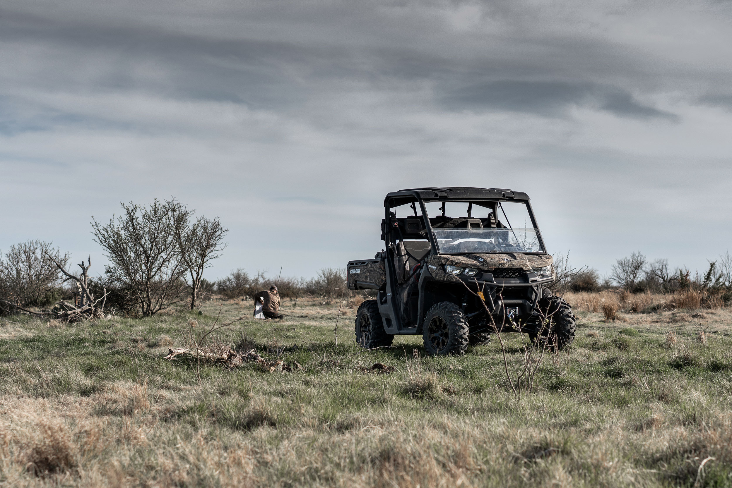 A Can-Am Defender side-by-side with Mossy Oak camouflage on a hunting ground