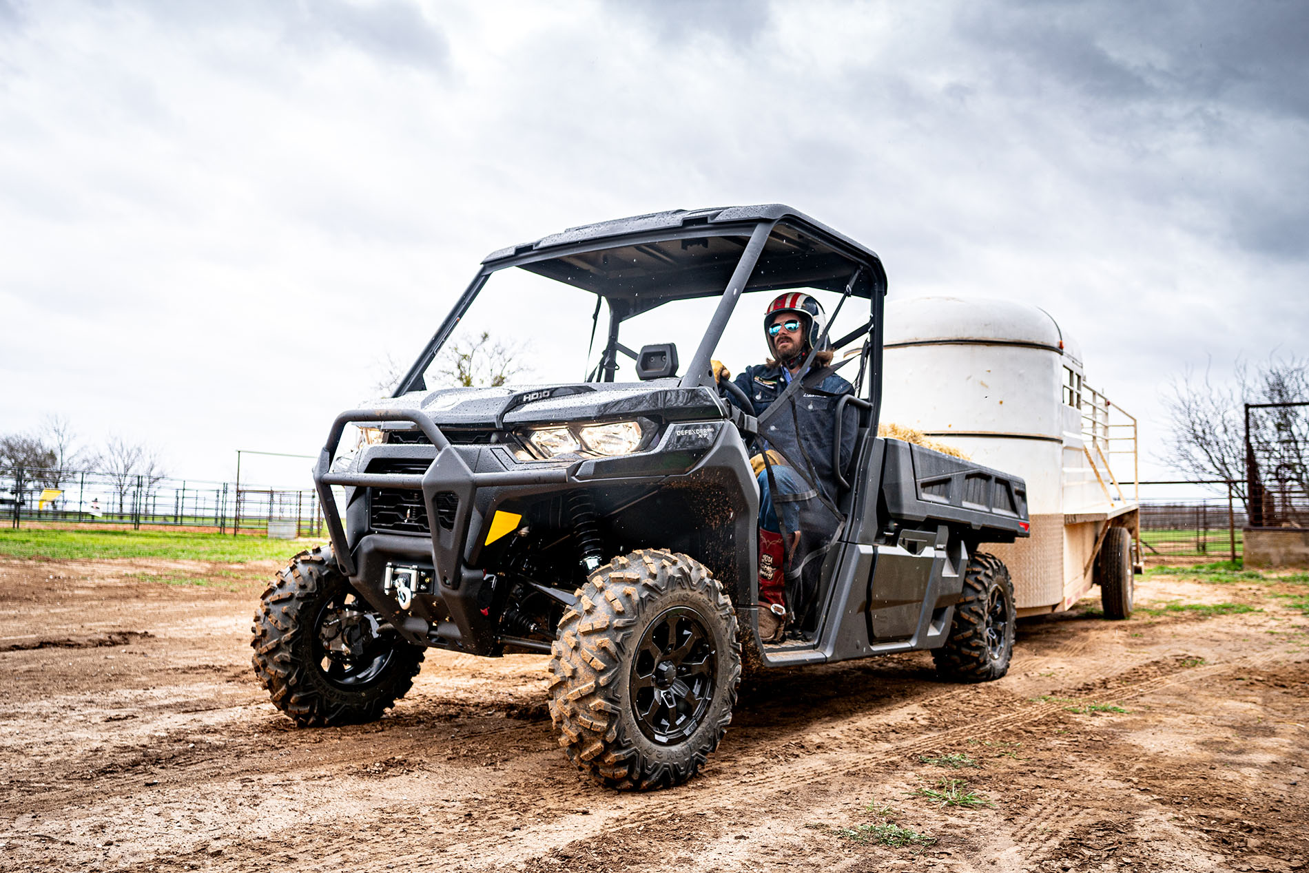 Dale Brisby towing a trailer at the farm with a Can-Am Defender side-by-side