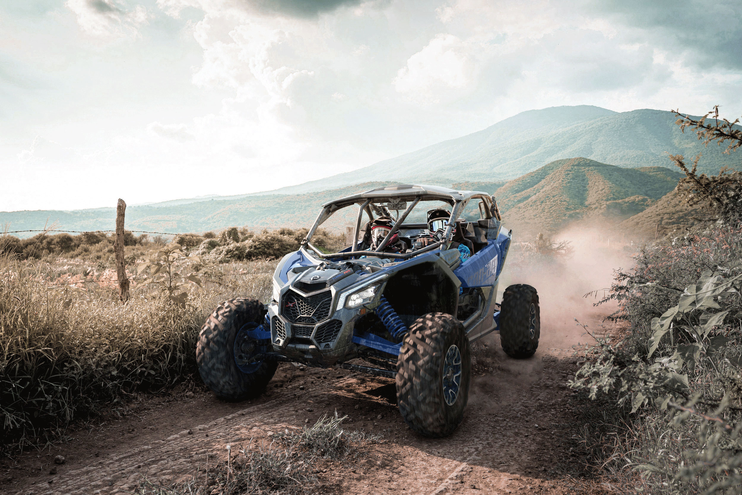 A blue Can-Am Maverick X rs Turbo RR side-by-side in a trail