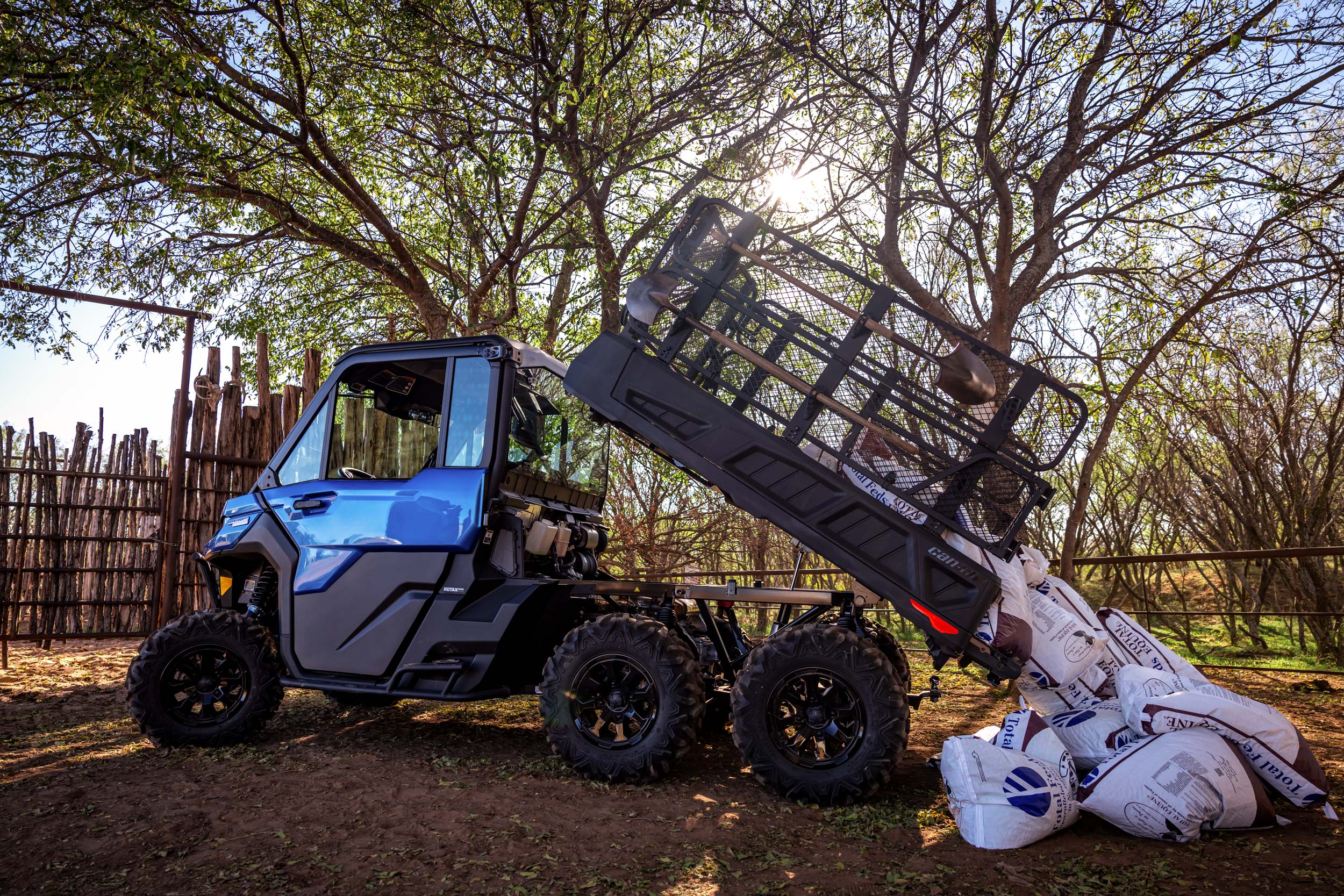An Oxford Blue Defender 6x6 Limited using the hydraulic bed to dump a load of grain bags