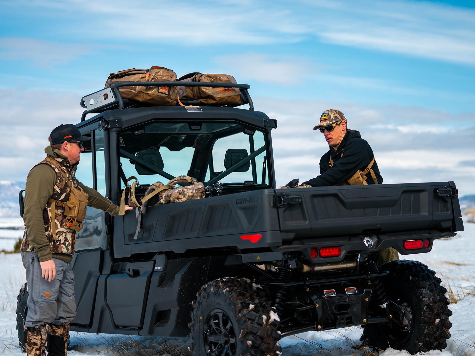 两位猎人正在 2024 Can-Am Defender Limited 排座式全地形车上装载货物
