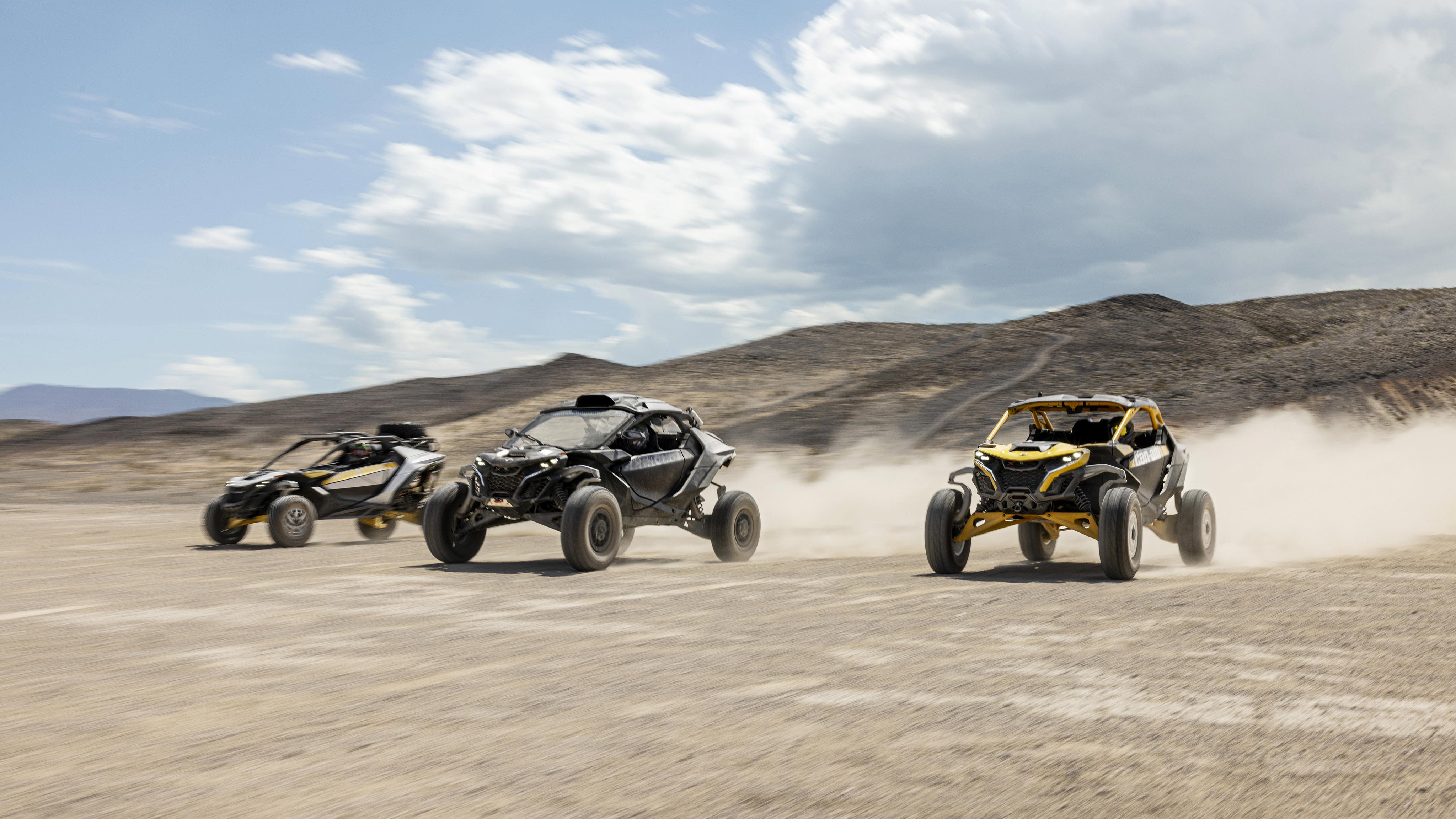 A trio of Can-Am SxS vehicles racing through the desert