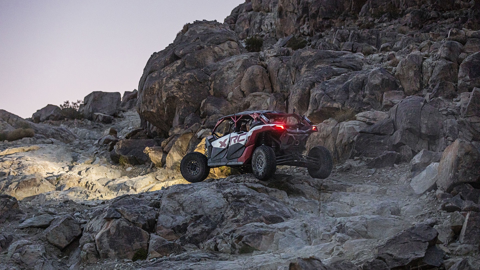 一辆 2024 Can-Am Maverick X3 正在攀爬一片石坡