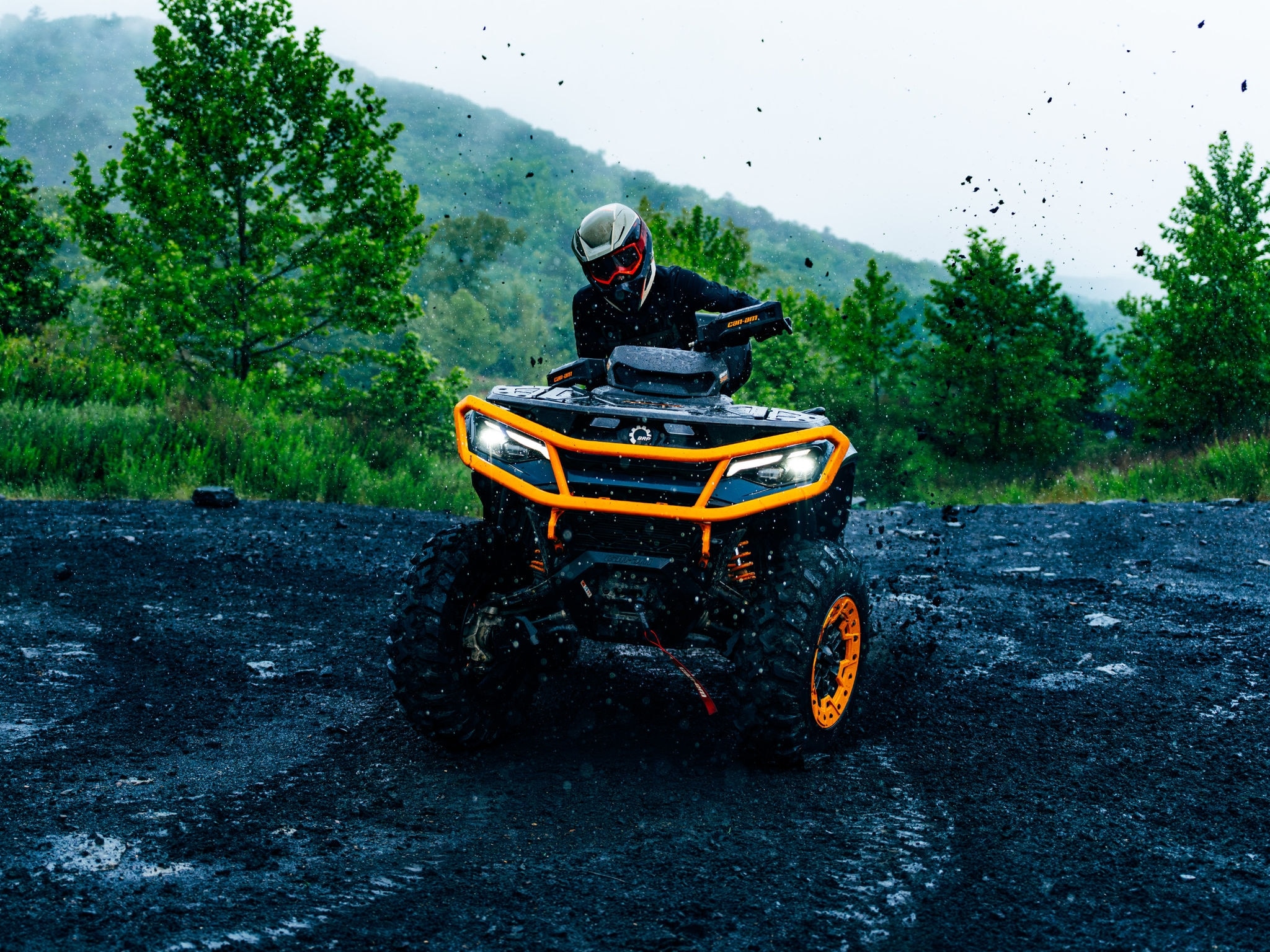 Outdoor enthusiast riding a Can-Am Outlander 850/1000R ATV in the mud