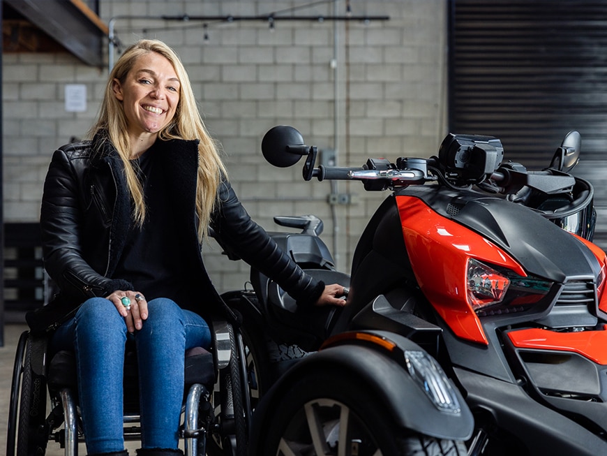 Can-Am Ambassador Sophie Morgan next to her Spyder three-wheeler in a garage
