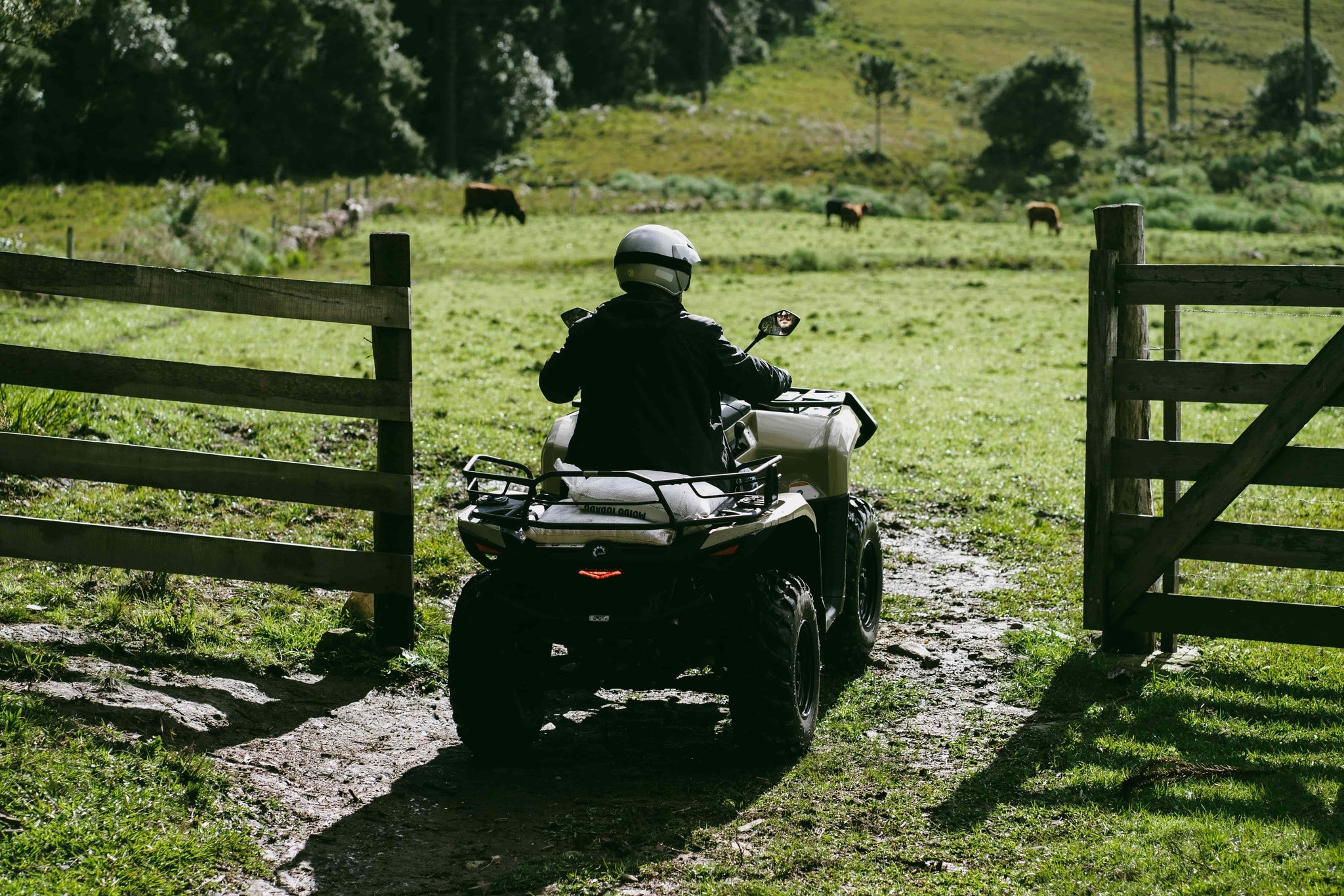 Can-Am Outlander Pro passando por um portão em um terreno enlameado.