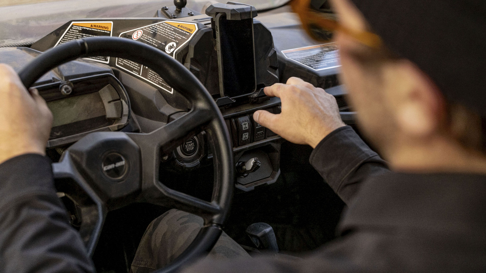 Conductor usando la aplicación BRP Go! en su teléfono dentro de su vehículo SxS