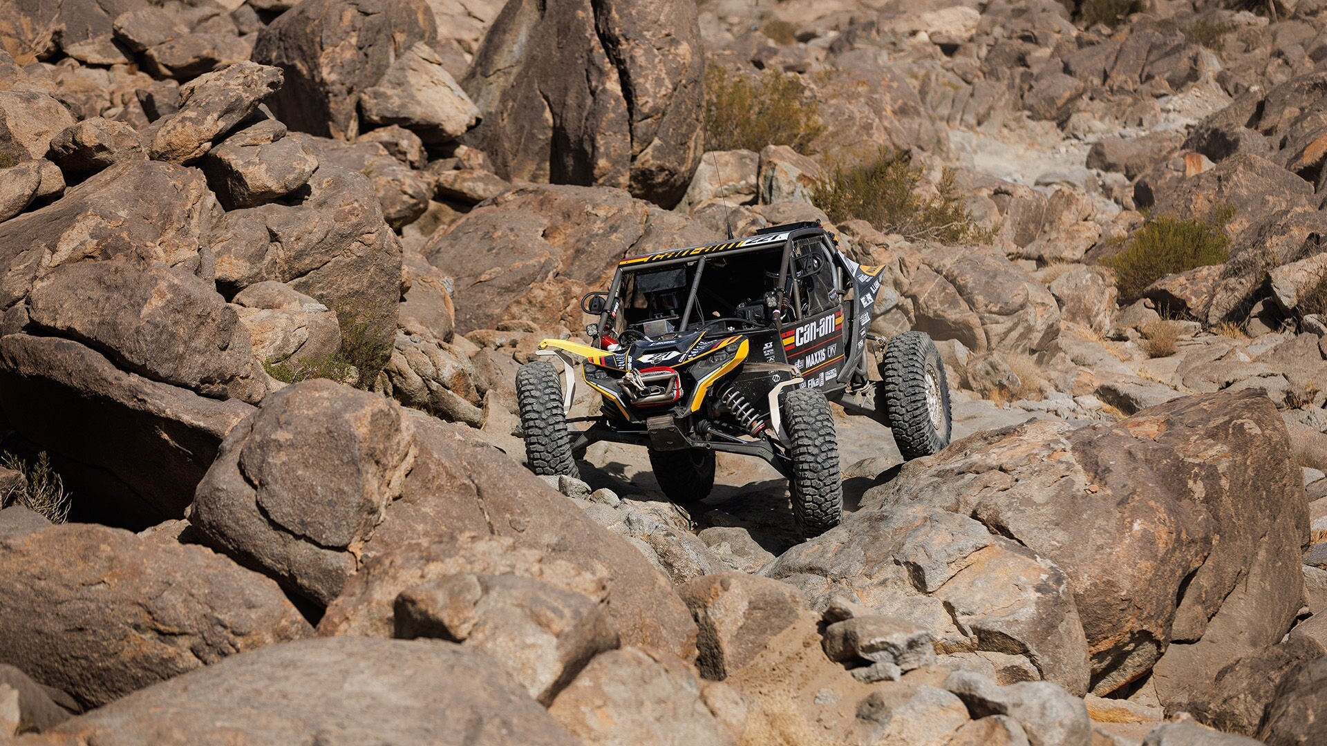 A Can-Am SxS doing rock crawling in the desert