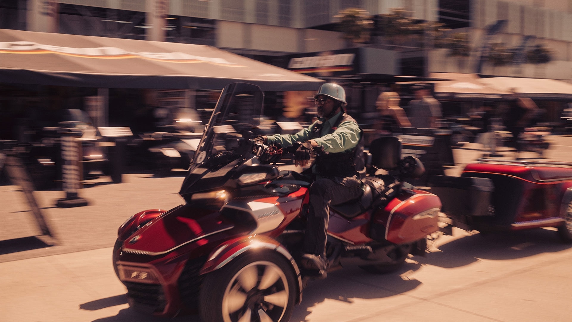 A modified red Can-Am three-wheeler driving around town