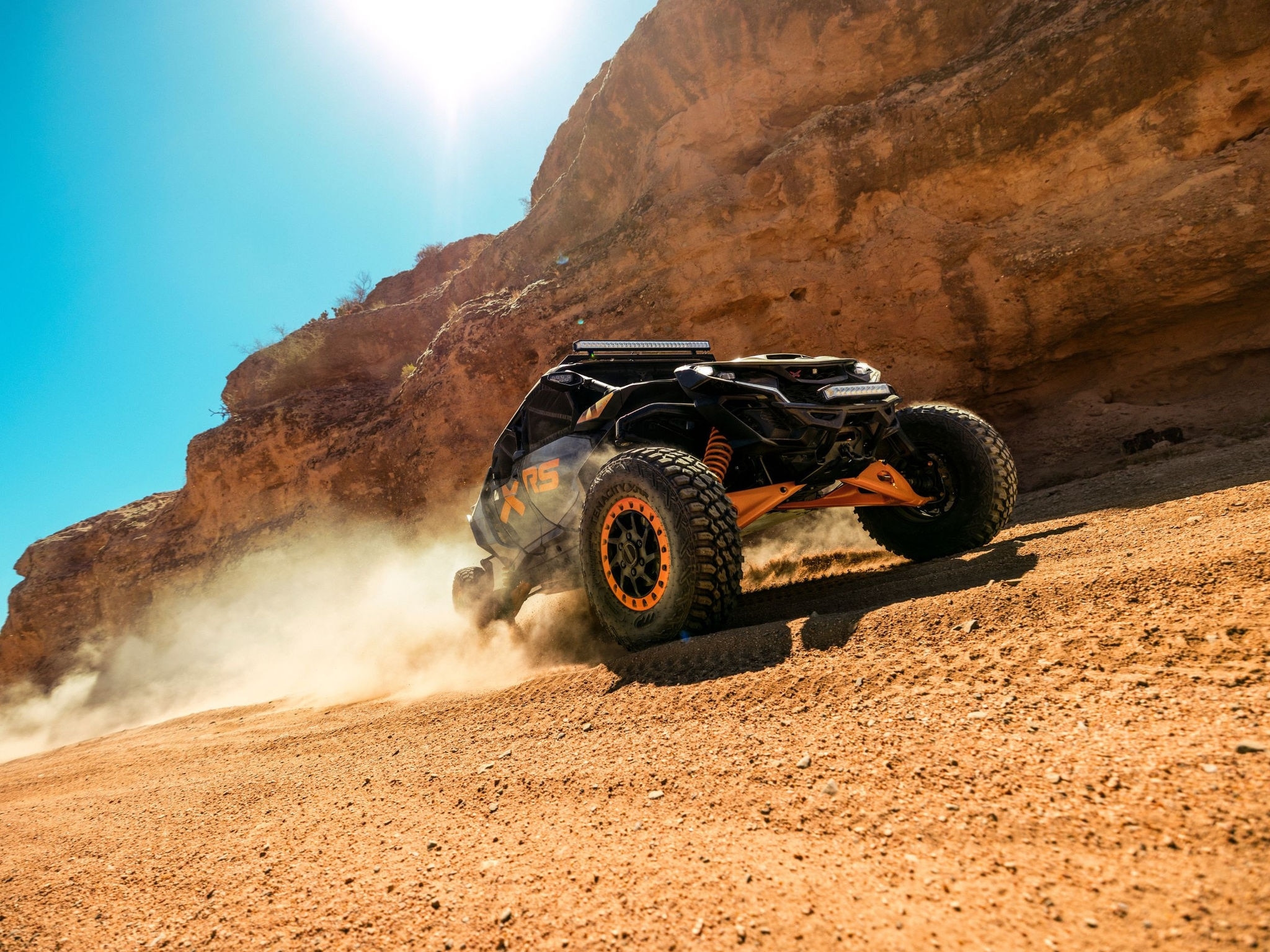 Can-Am Maverick MAX X-RS 2027 fährt im Sand neben einer Felswand