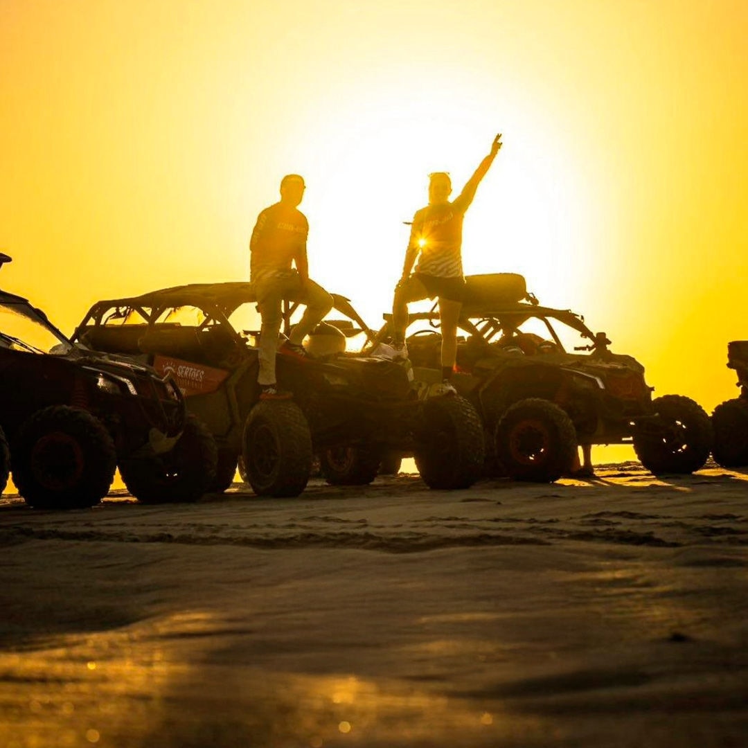 Quatro Can-Am SSV e dois pilotos ao pôr do sol