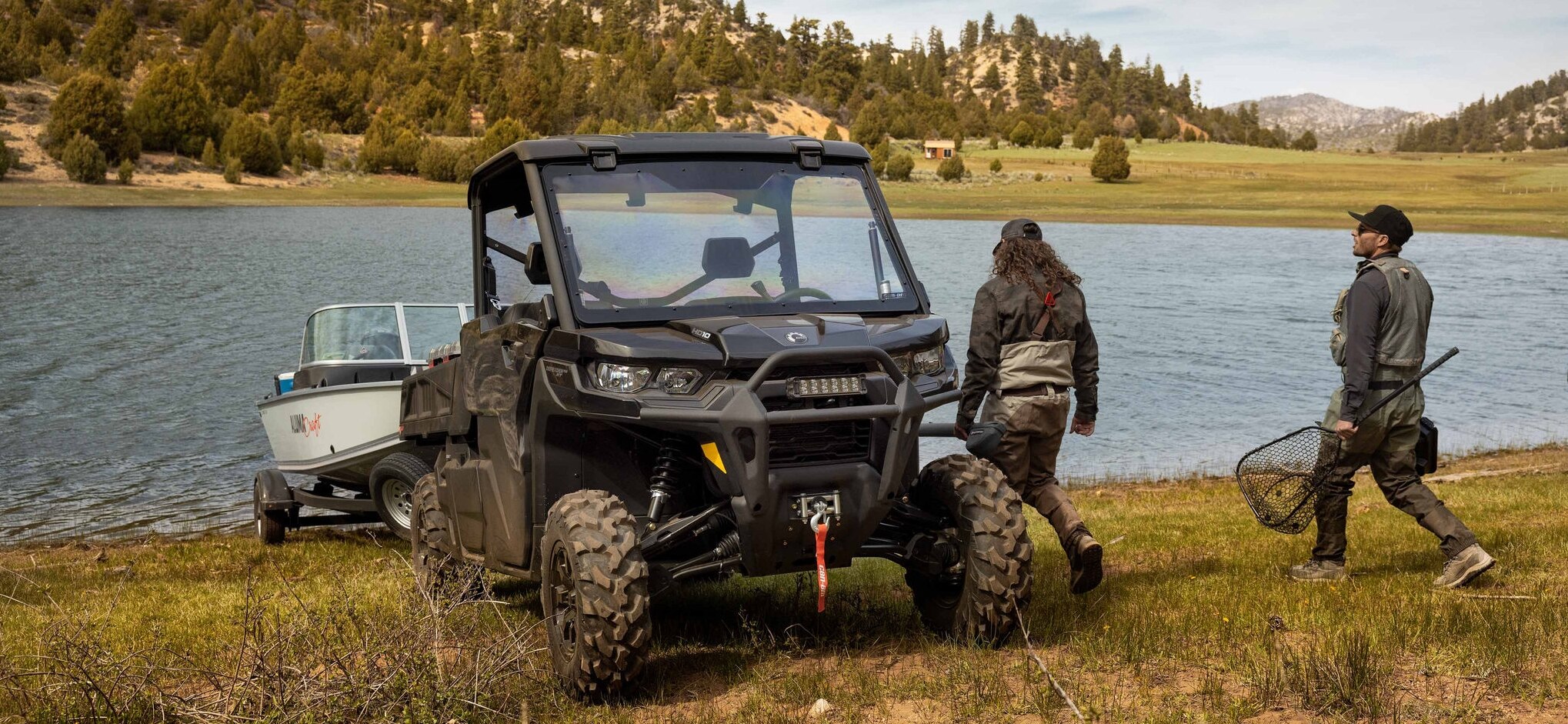 Deux hommes près d’un lac avec un Can-Am Traxter Pro 