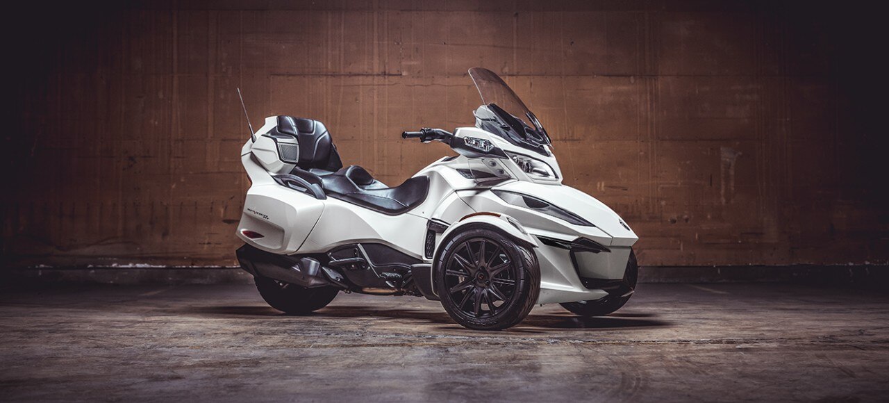 Homem colocando o capacete ao lado do seu Can-Am Spyder RT