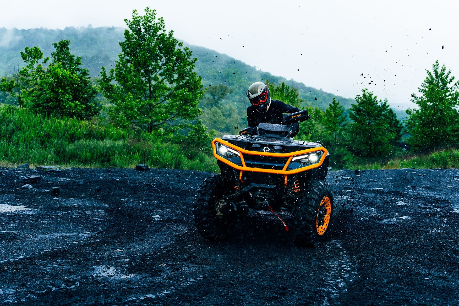 2027 Can-Am Outlander Quad fährt durch eine schwarze Schlammpfütze