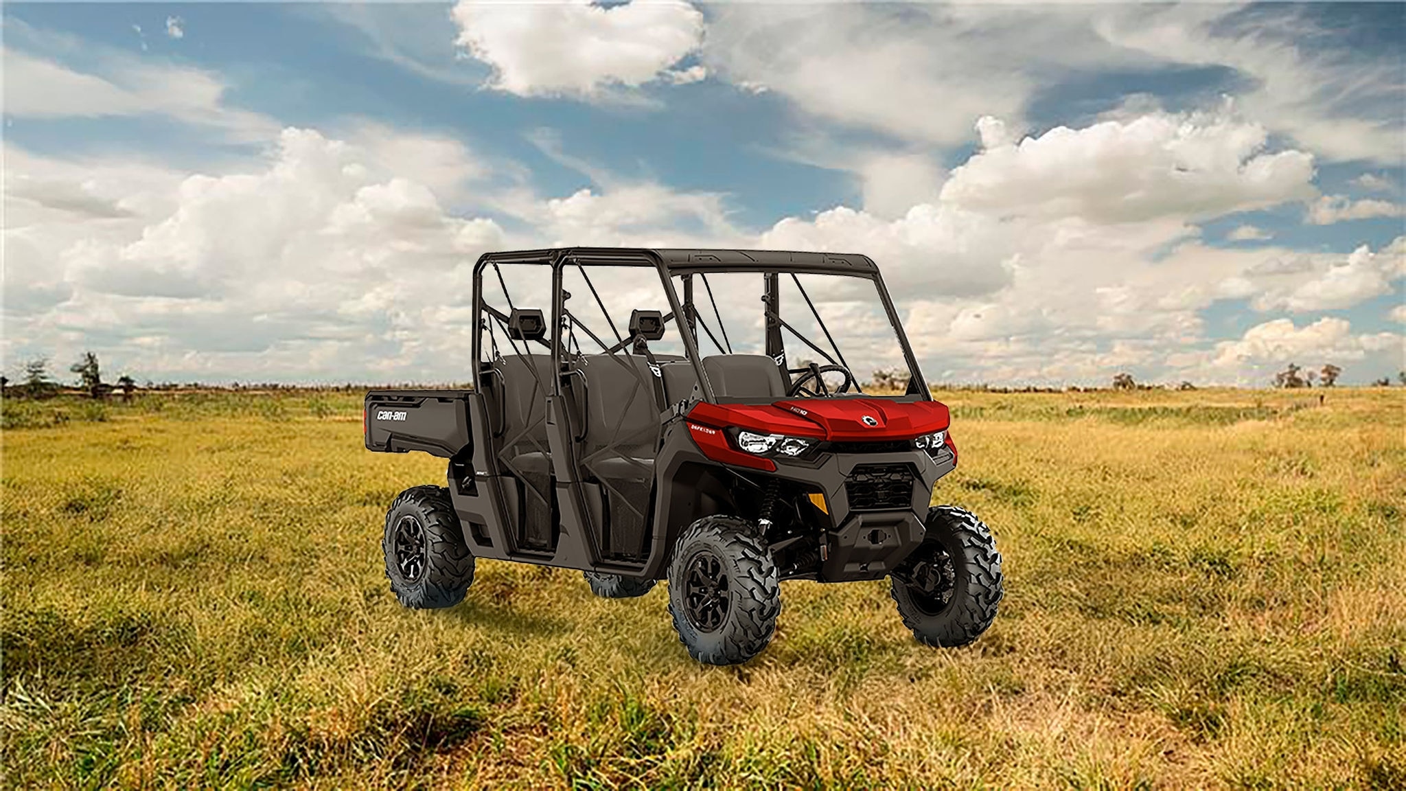 Can-Am Defender Max estacionado em terreno com mato baixo.