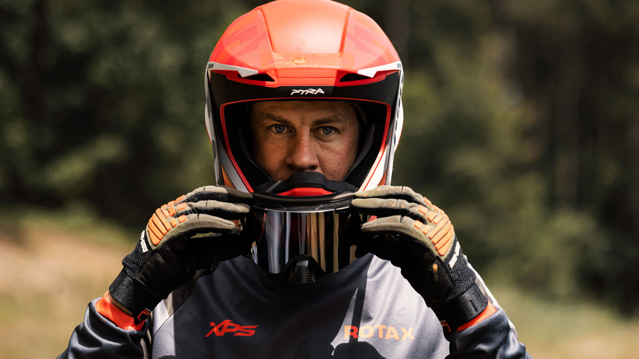 hombre ajustándose el casco para dar un paseo Off-Road con su Can-Am Gear