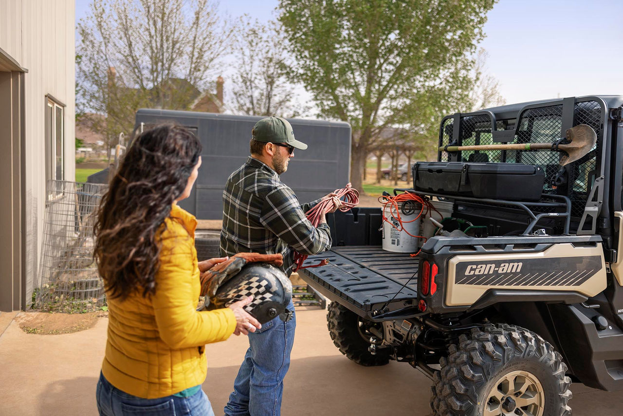 Un homme et une femme chargent une cargaison sur leur Can-Am Defender