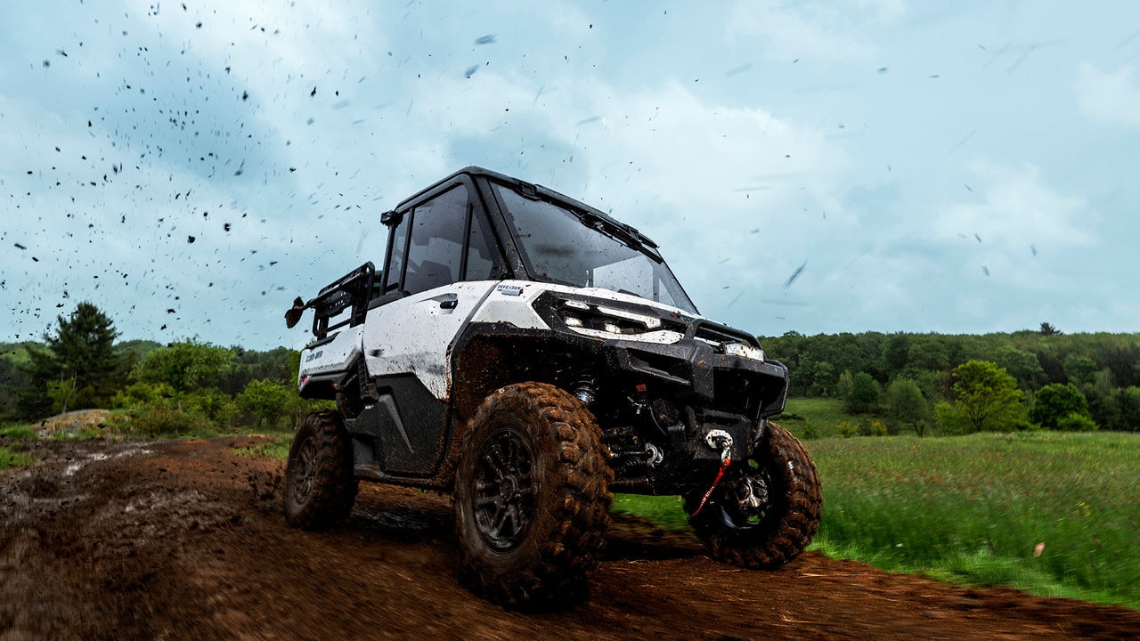 2026 Can-Am Defender HD11 blanc hybride sur un chemin de terre