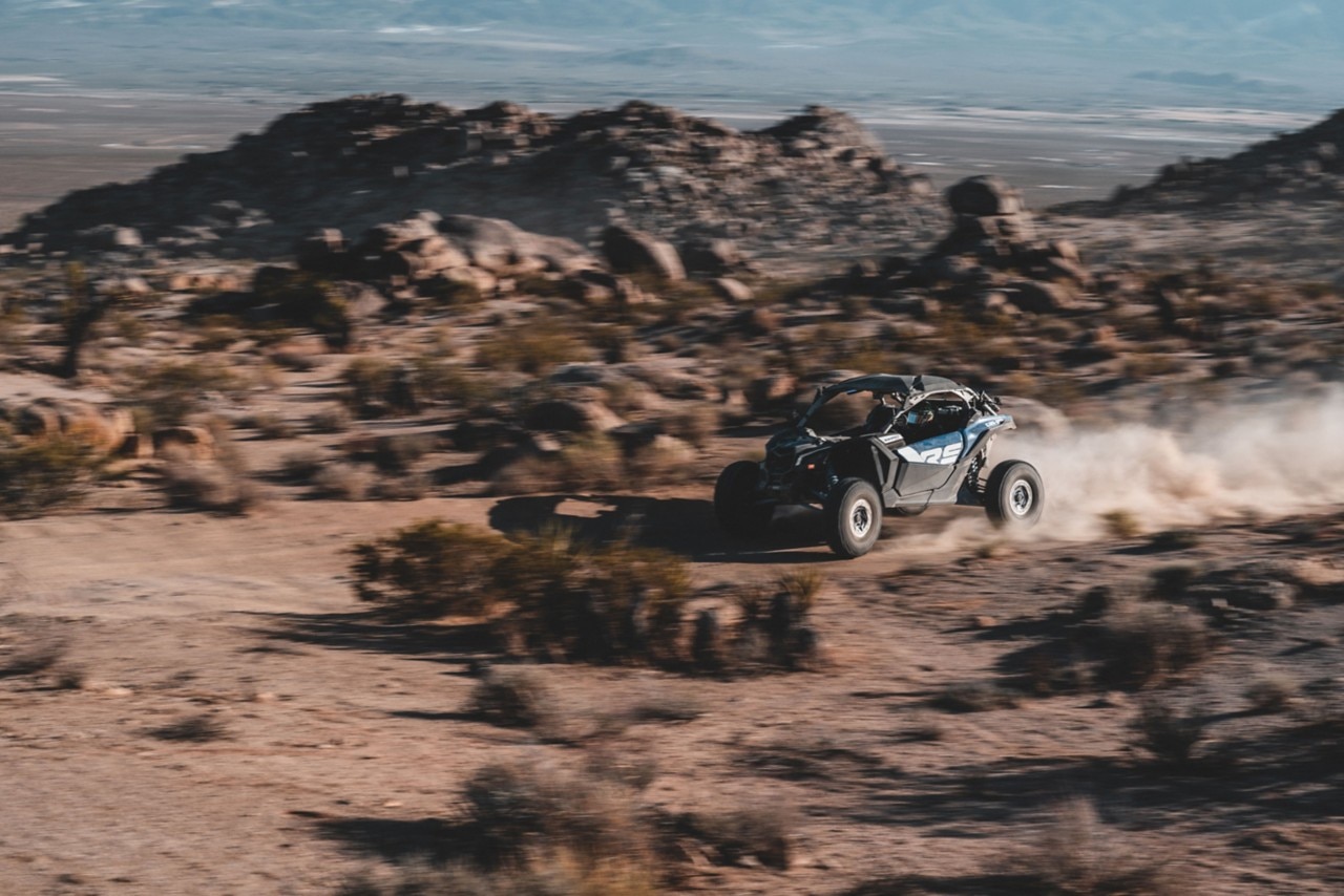 En Can-Am Maverick R i full fart i ørkenen.