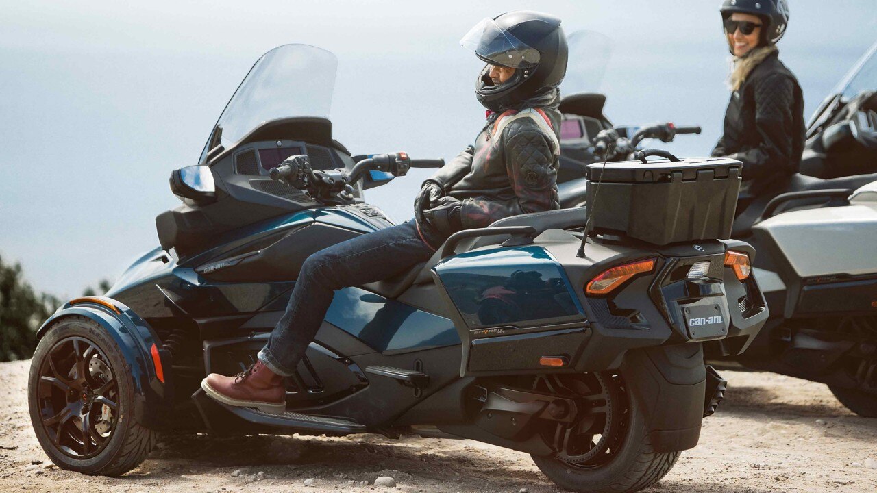 Two riders relaxing on their 3-wheeled motorcycle