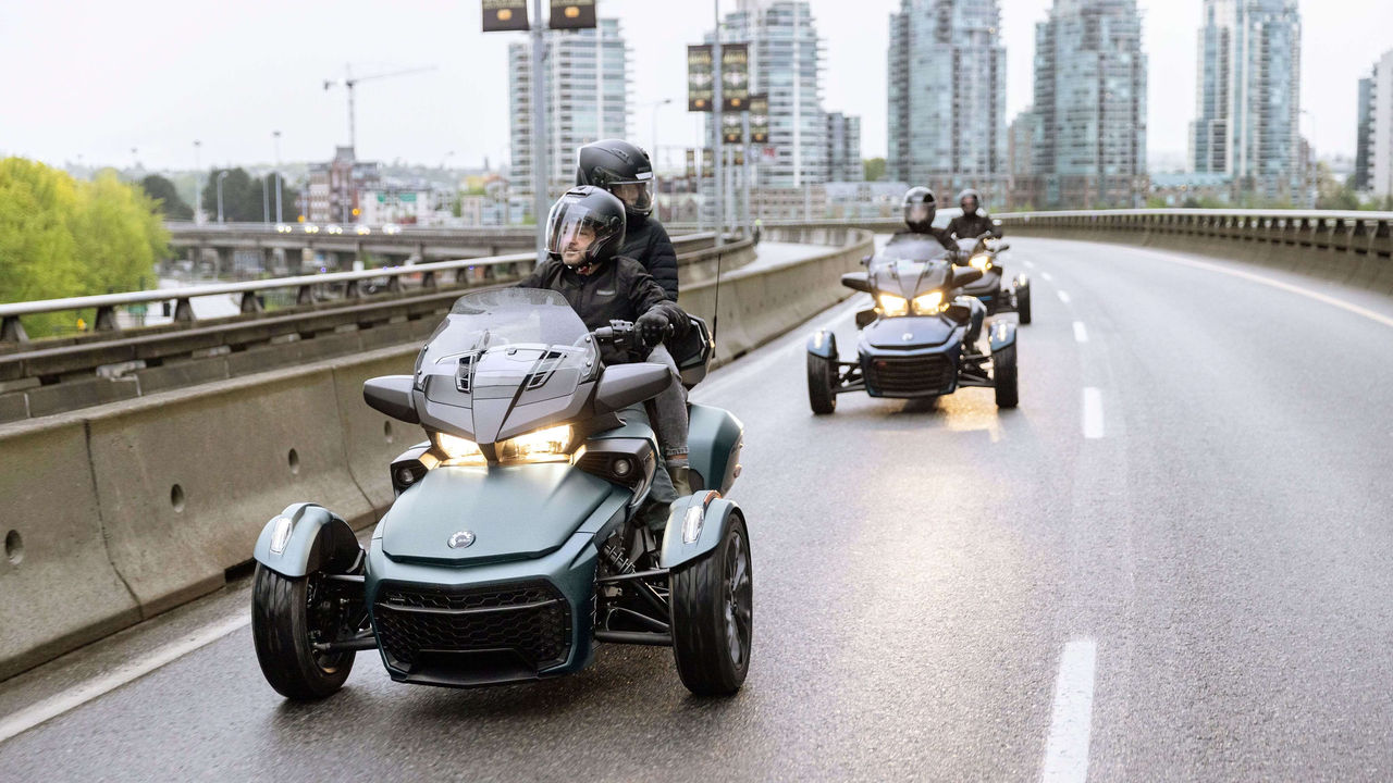 Three 3-wheeled vehicles following each other around town
