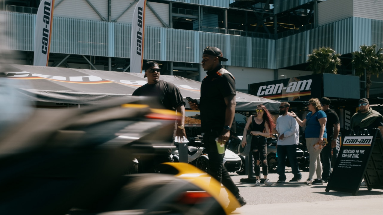 Des personnes marchant devant un kiosque Can‑Am