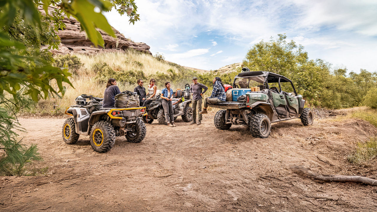 A group of friends taking a break near their Can-Am ATV & Side-by-Side