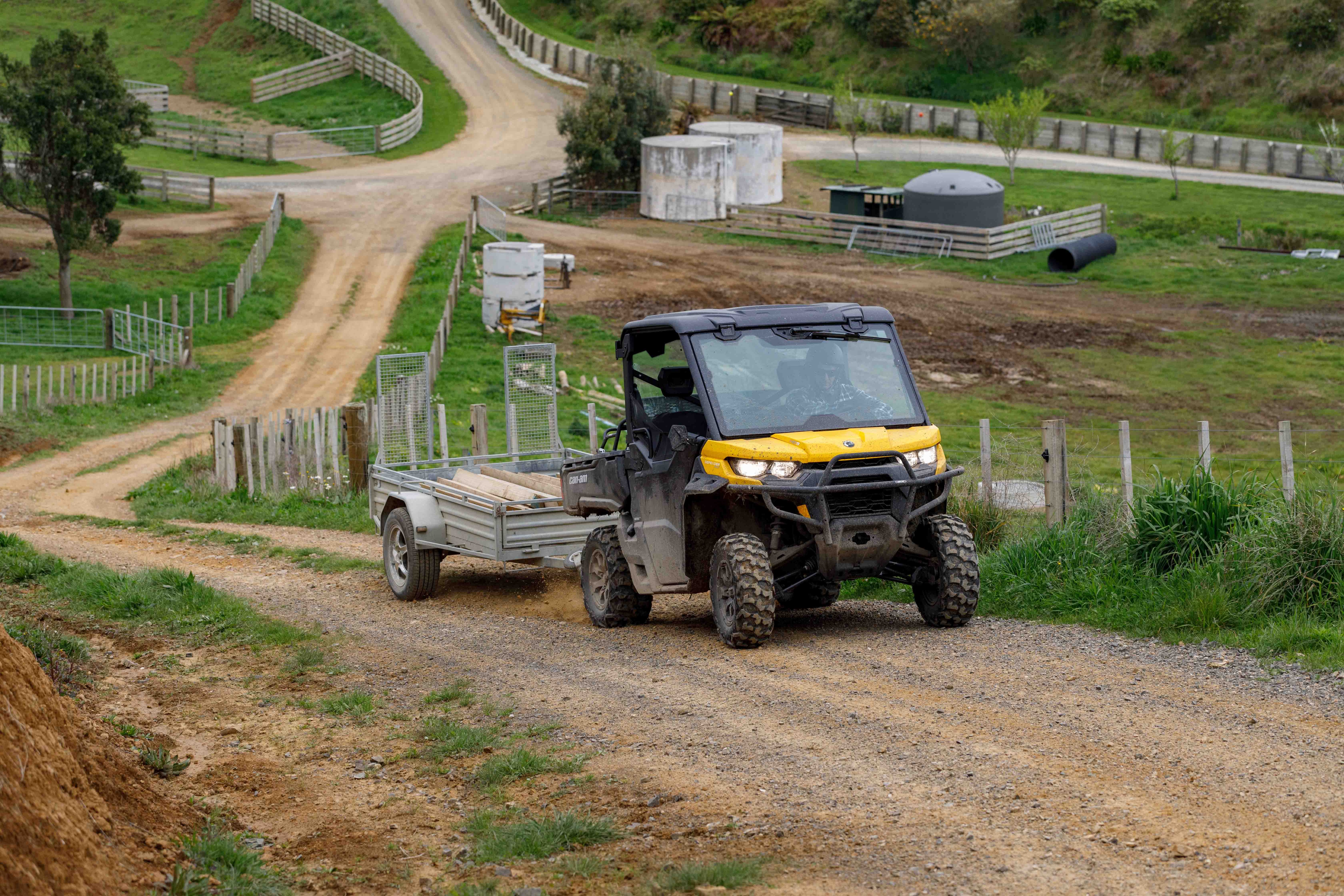 Can-Am Defender towing a trailer on dirt trail 