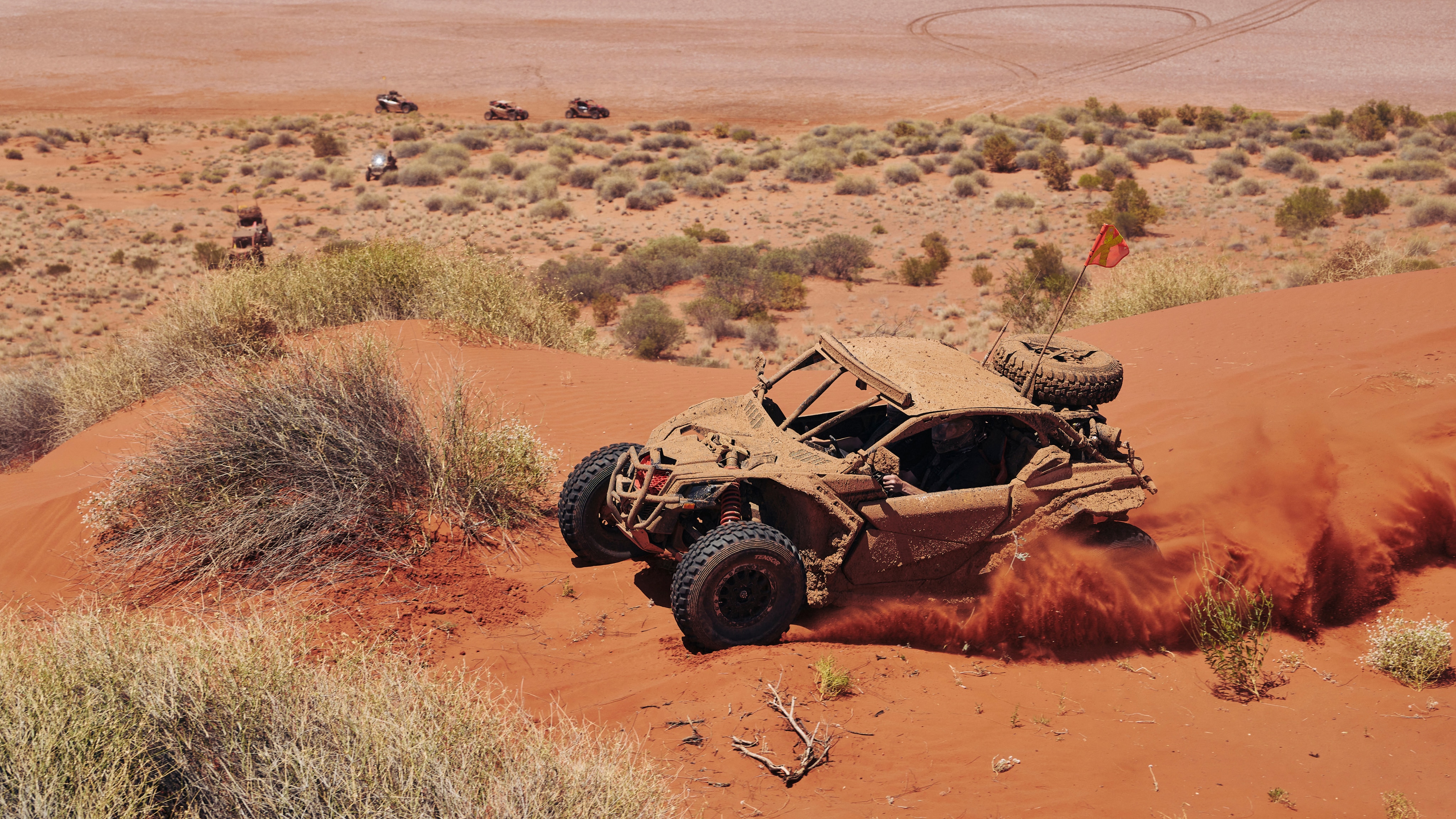 Can-Am X3 drifting through red desert sand 