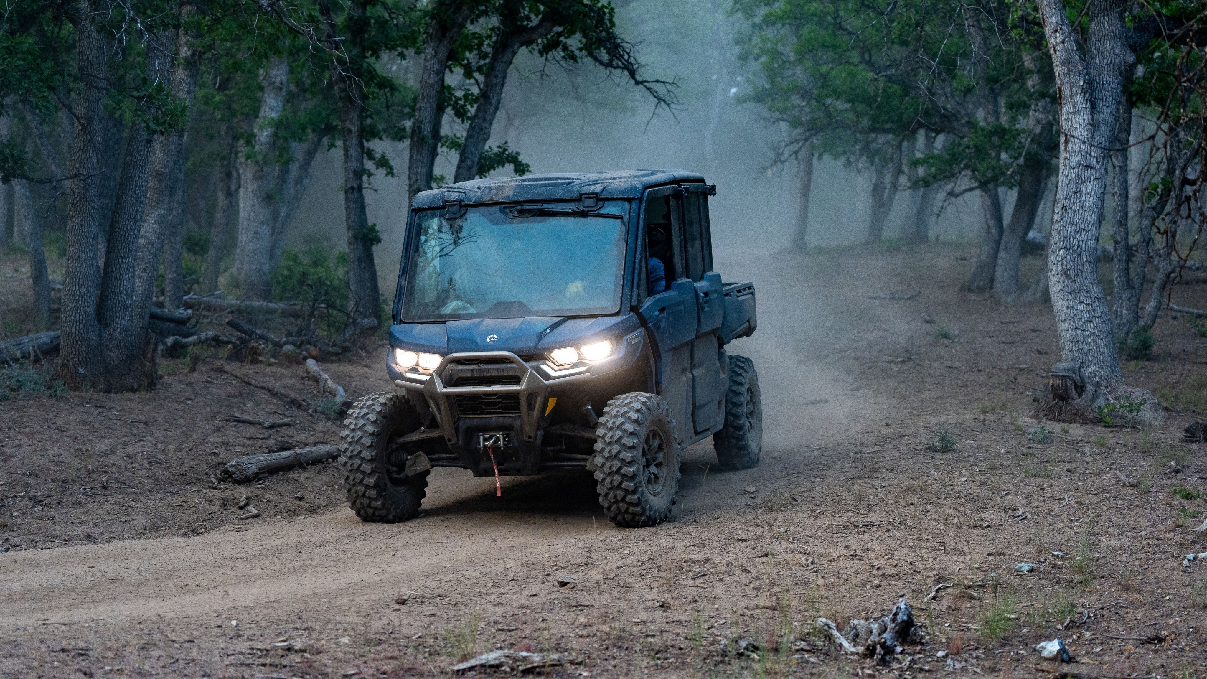 Can-Am Defender driving down a dirt road