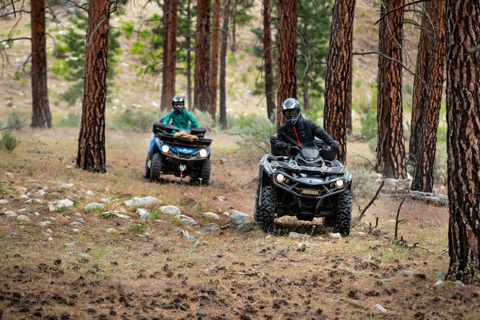 People riding a Can-Am Outlander in the forest