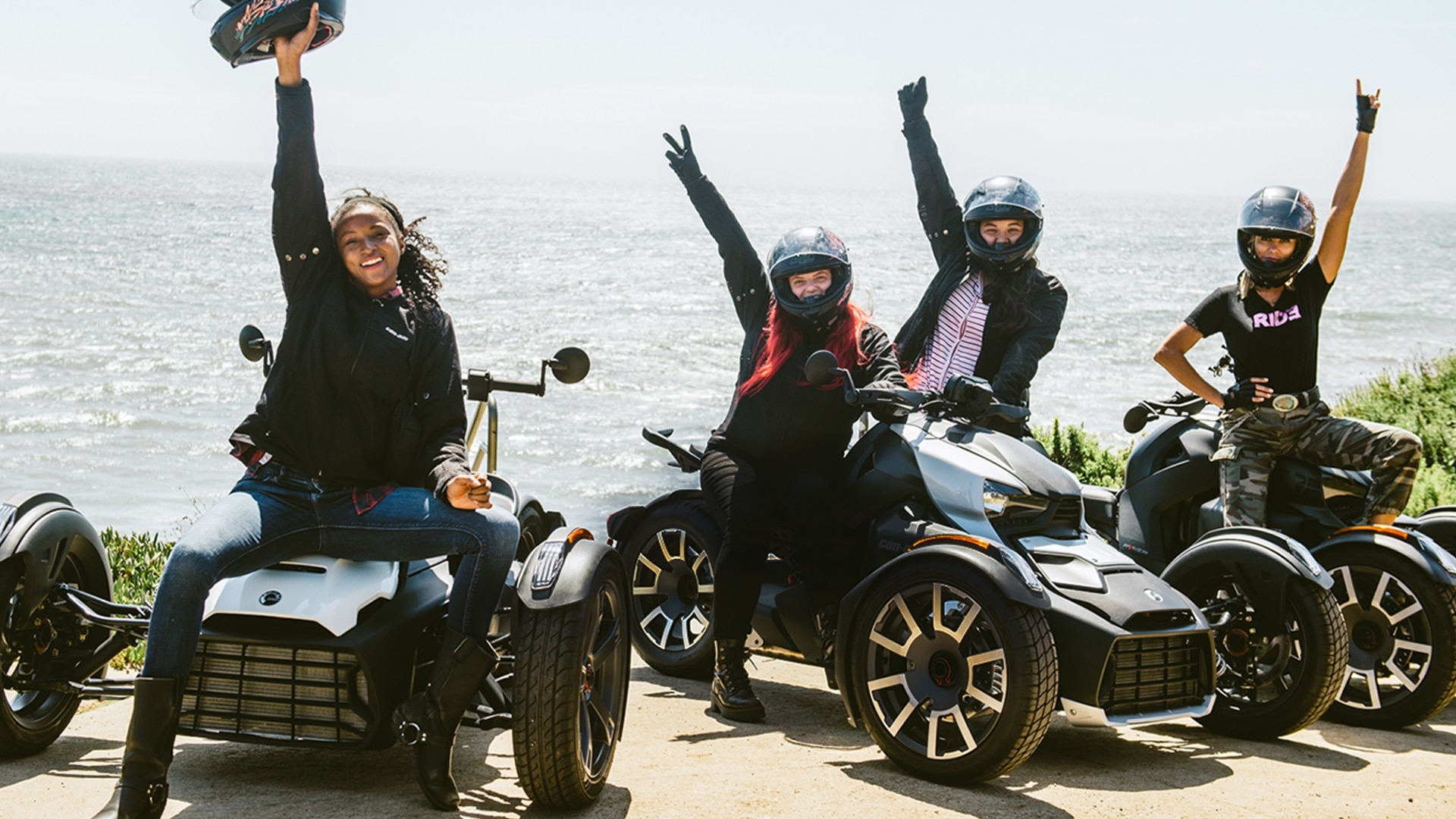 Women sitting on their Can-Am Ryker and raising their arm in the sky