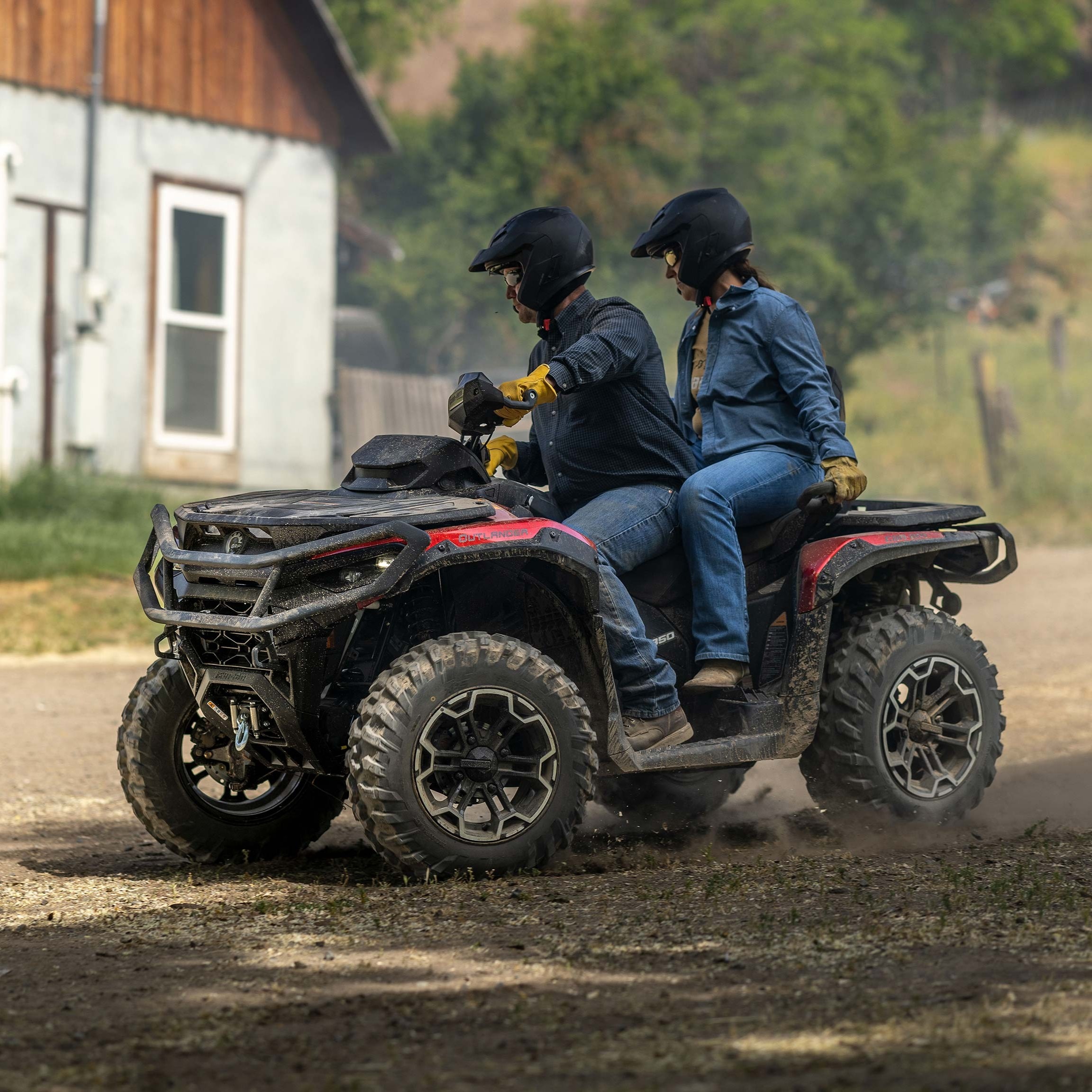 Ein Fahrer und sein Beifahrer fahren mit einem Can-Am Quad auf einer Schotterstraße