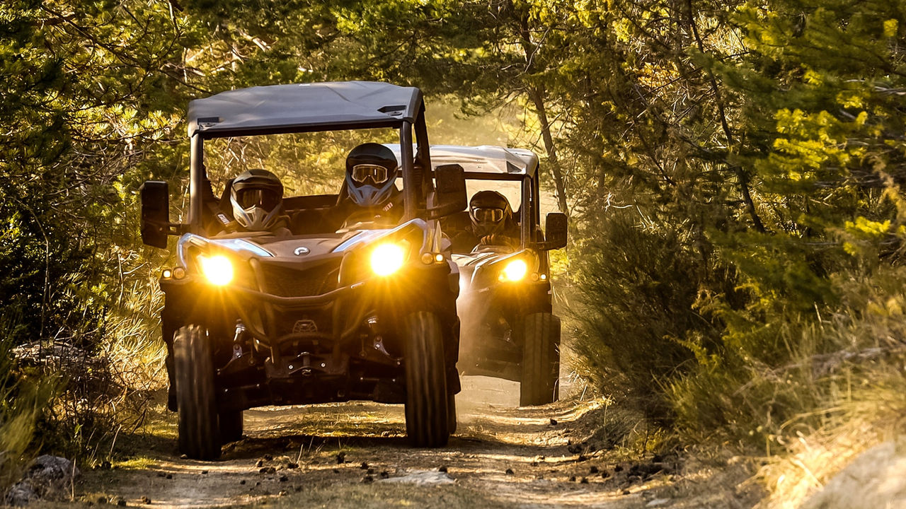 Två personer kör en Can-Am Maverick Sport på en lerig led