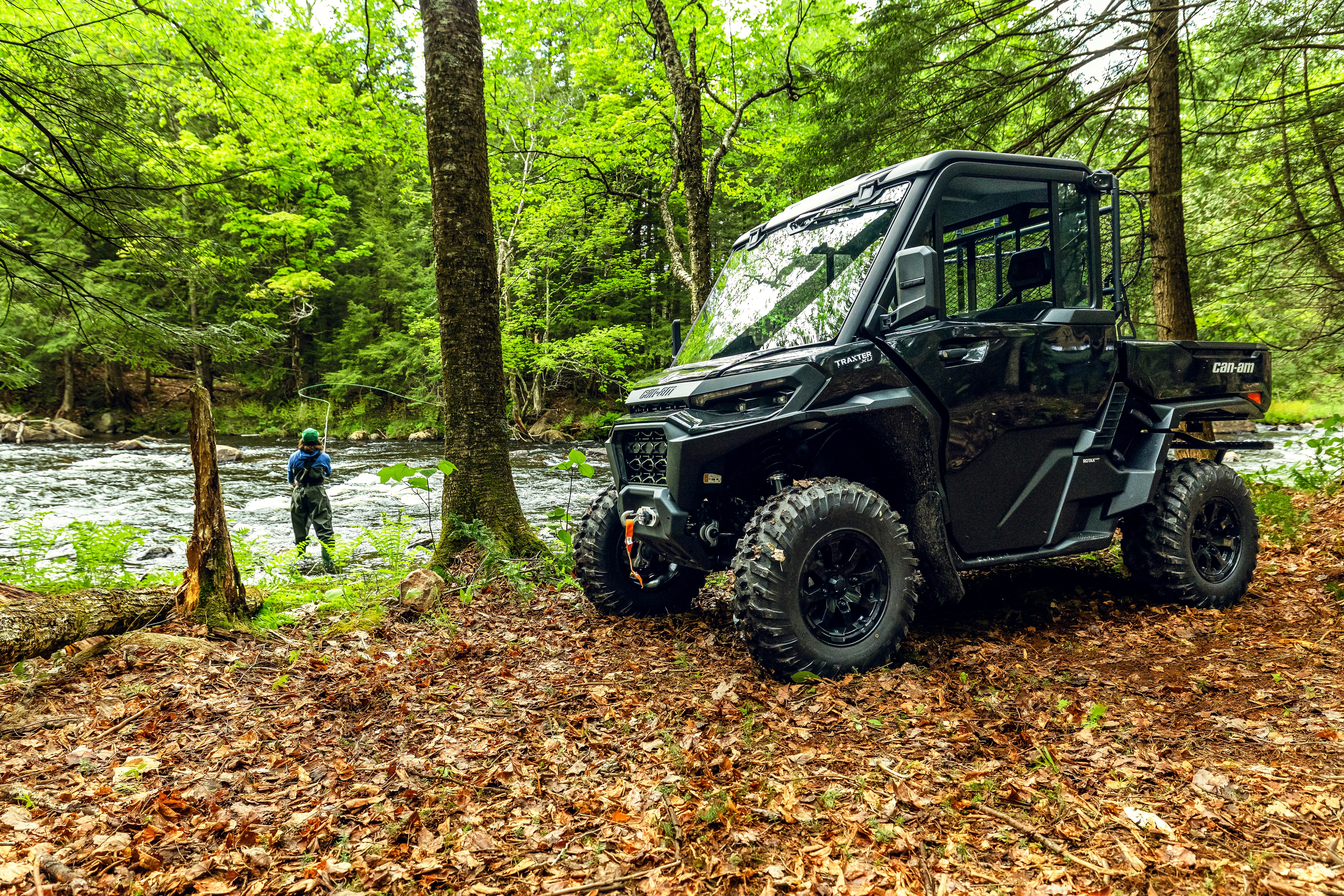 Le Traxter XU HD11 ABS dans une forêt près d’une rivière