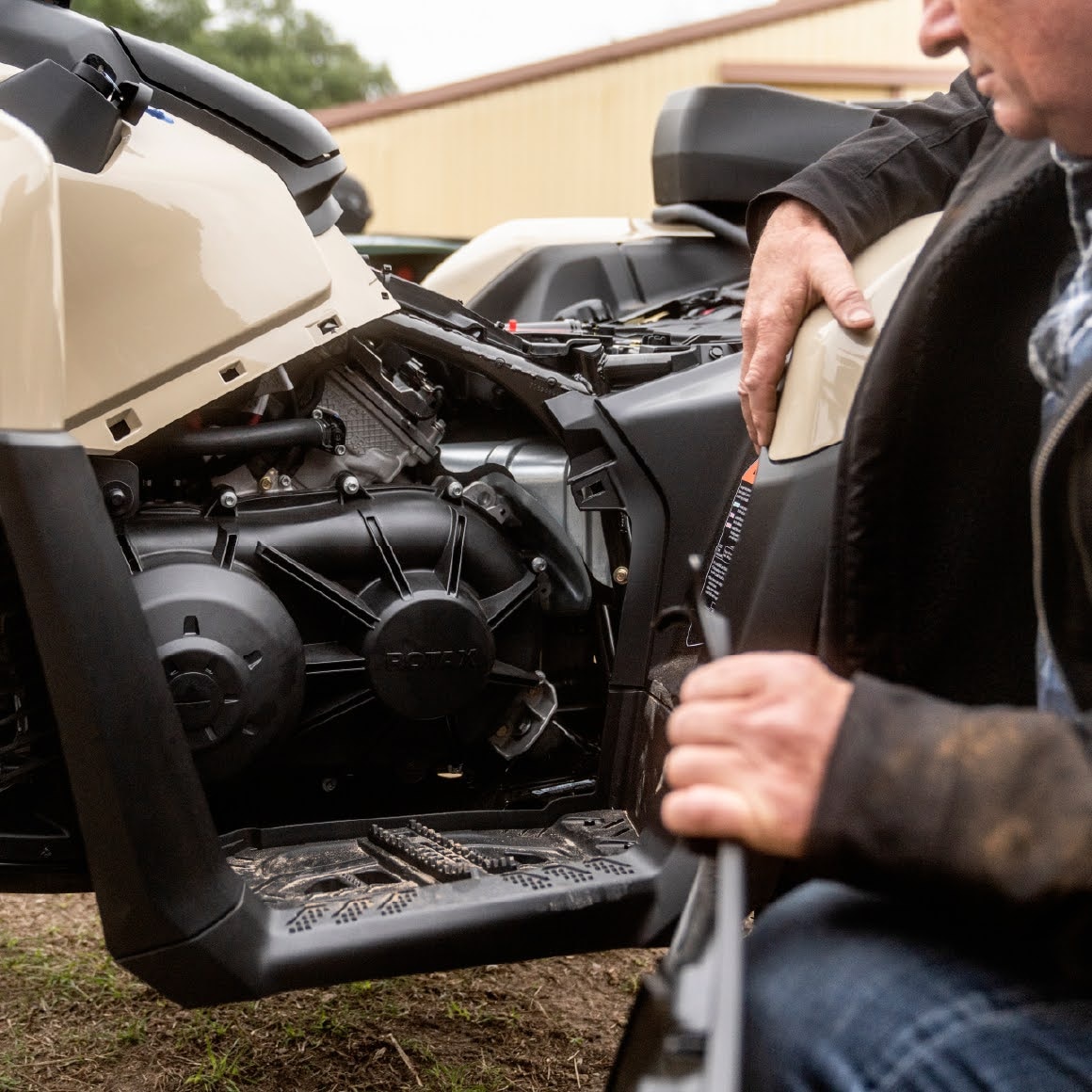 Farmer inspecting the engine compartment of a Can-Am Outlander