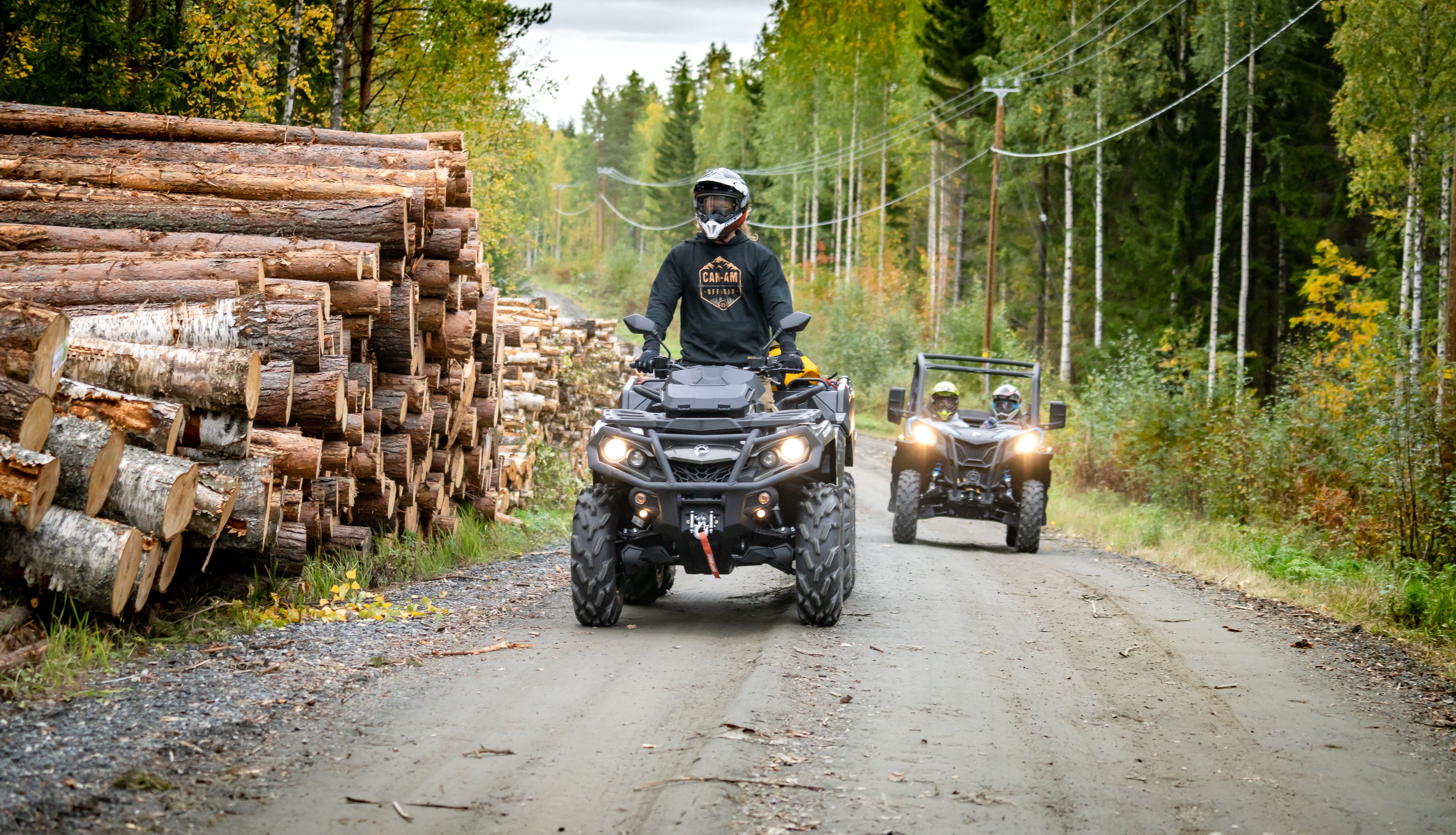 Miehet ajamassa metsätiellä Can-Am-ajoneuvoillaan