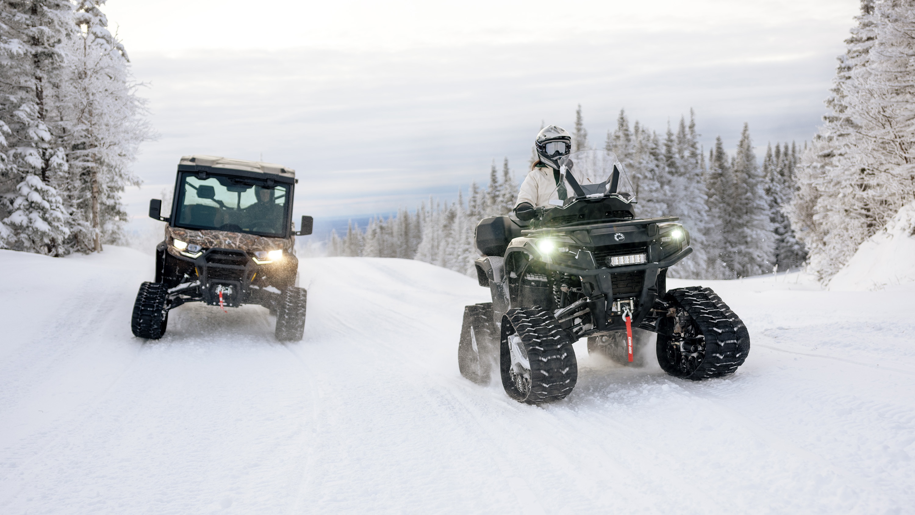 Side-by-side vehicles Defender and Maverick X3 riding equipped with the Apache LT track system