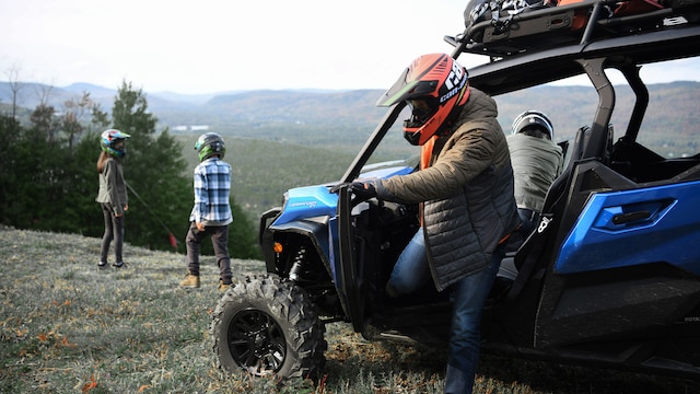 Mehrere Fahrer machen eine Pause neben ihrem Can-Am Commander Max XT Side-by-Side.