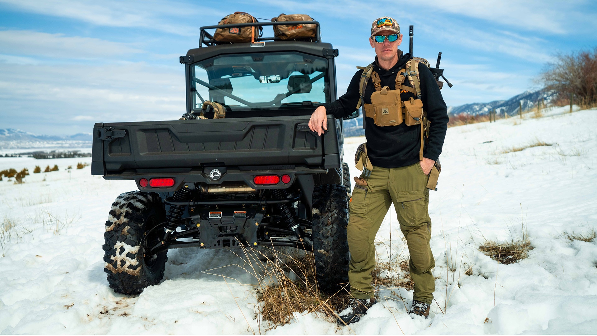 Un cazador junto a un vehículo todoterreno Can-Am Defender