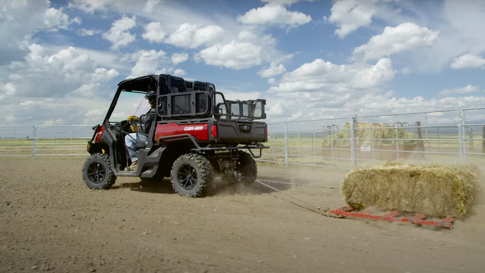 Can-Am Defender pulling a bale of hay
