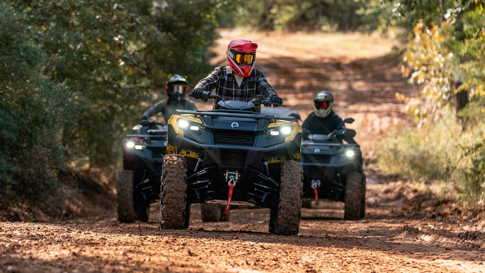 Can-Am riders driving ATVs on a trail