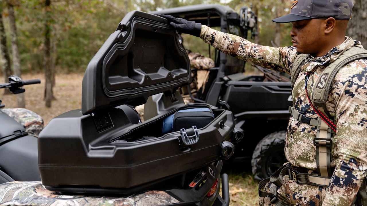 A hunter opening the rear trunk of a 2023 Outlander PRO ATV