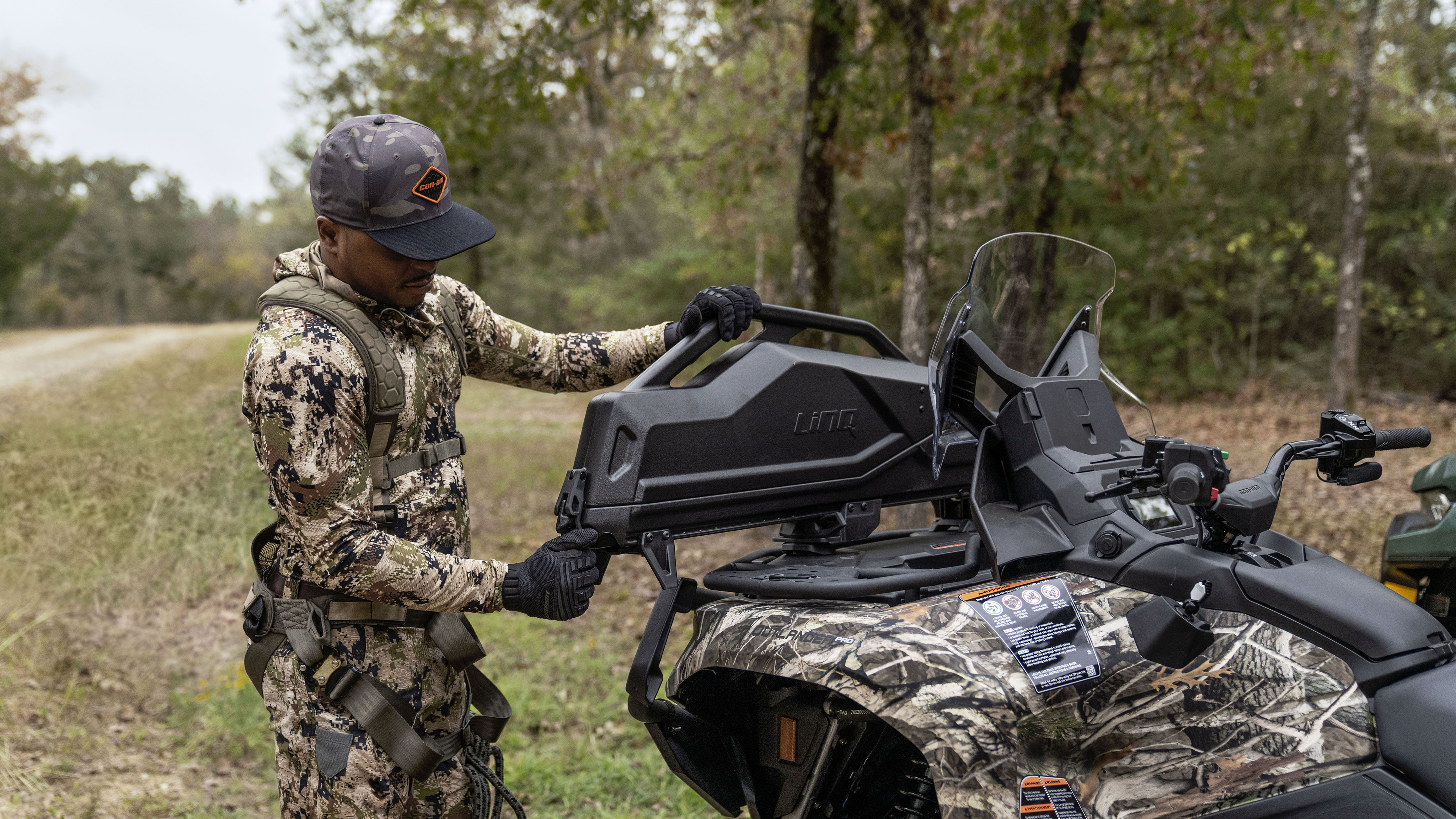 A hunter clipping his LinQ gun boot case closed on the back of his Can-Am Oulander Hunting Edition